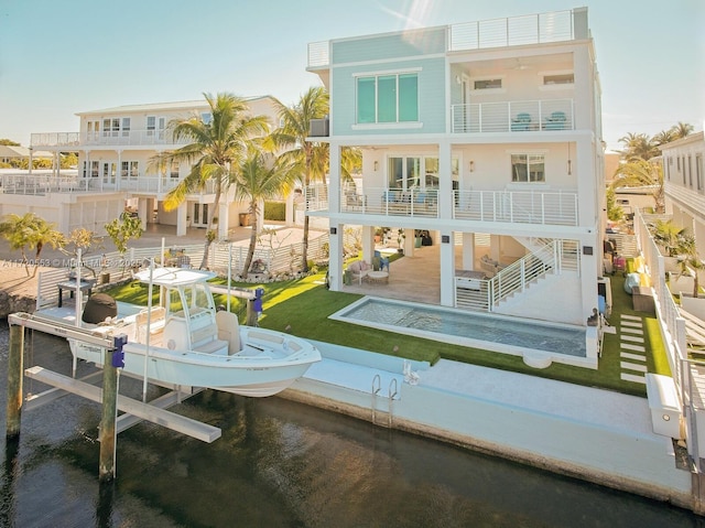 back of property featuring a balcony, a patio, and a pool