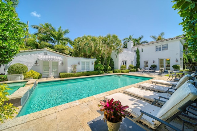 view of swimming pool with french doors and a patio