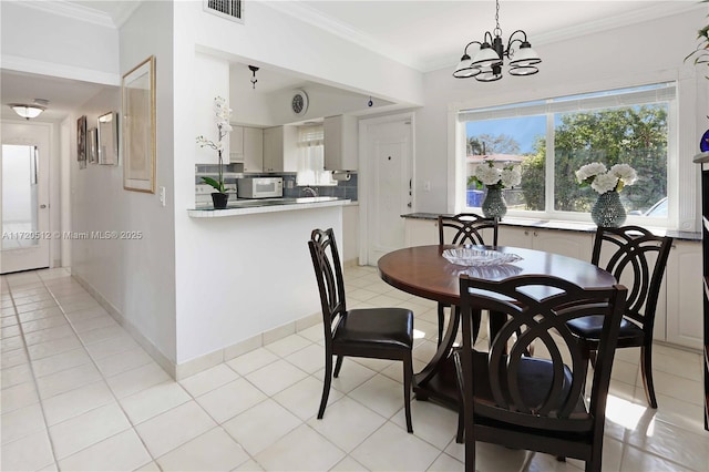 tiled dining area with a notable chandelier and ornamental molding