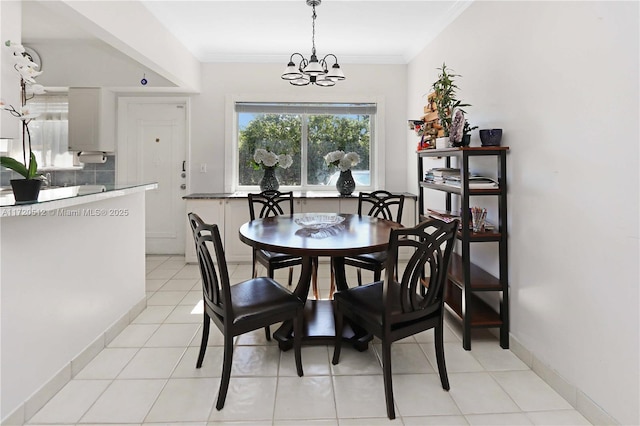 dining room with light tile patterned flooring, ornamental molding, and an inviting chandelier