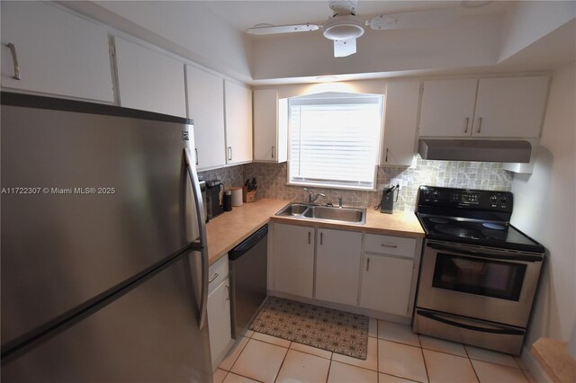 kitchen featuring stainless steel appliances, light tile patterned floors, white cabinets, ceiling fan, and sink