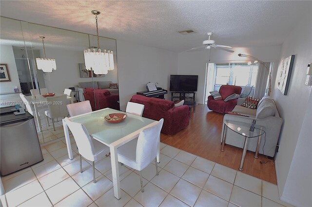 dining space with a textured ceiling, ceiling fan, and light tile patterned floors