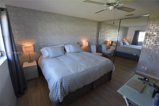 bedroom with ceiling fan, a closet, a textured ceiling, and wood-type flooring