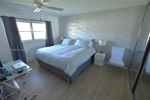 bedroom featuring ceiling fan, a textured ceiling, and hardwood / wood-style flooring