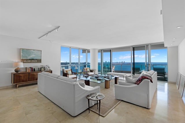 living room featuring floor to ceiling windows, a water view, and track lighting