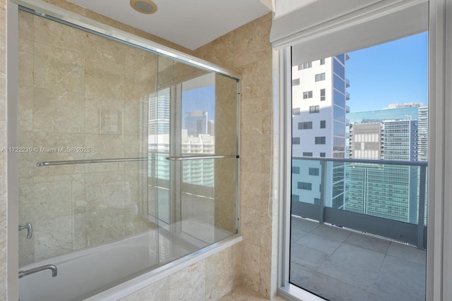 bathroom featuring shower / bath combination with glass door and tile patterned flooring