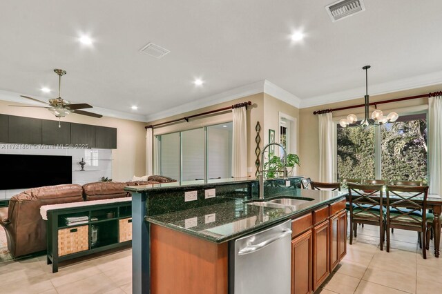 kitchen featuring dark stone counters, sink, pendant lighting, dishwasher, and an island with sink