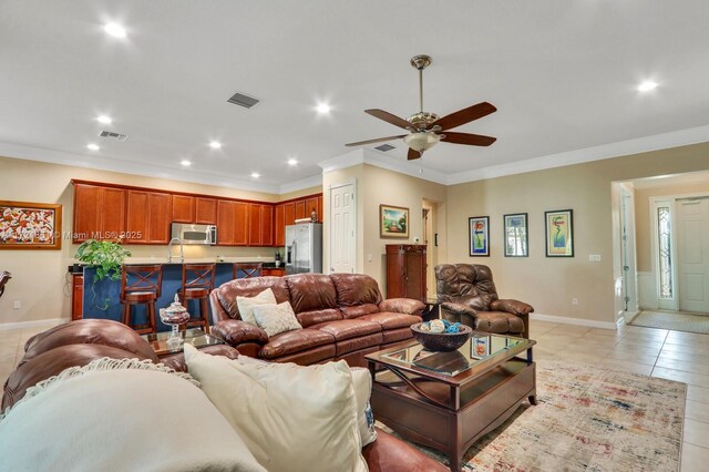 living room with ceiling fan, sink, light tile patterned floors, and ornamental molding