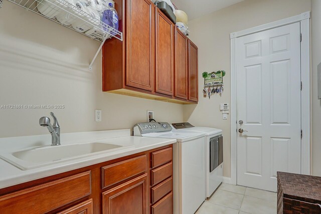 washroom with washing machine and dryer, sink, light tile patterned floors, and cabinets