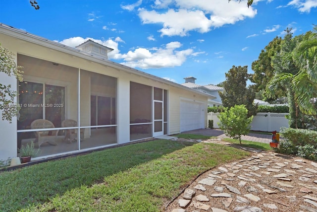 view of yard featuring a sunroom and a garage