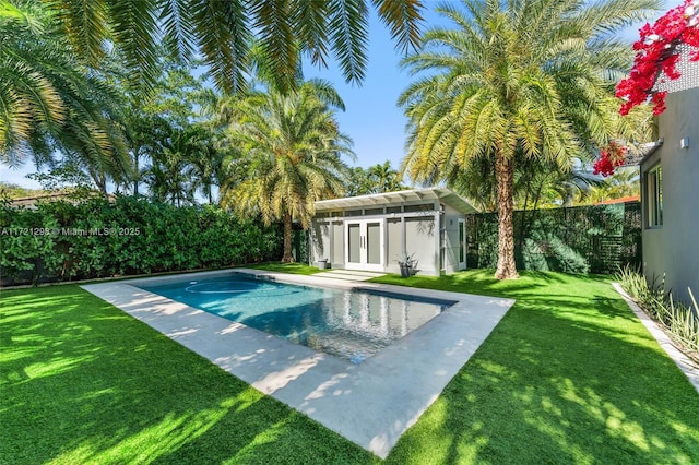 view of pool with a fenced backyard, a yard, and an outdoor structure