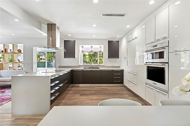 kitchen featuring white cabinets, sink, black electric cooktop, stainless steel double oven, and extractor fan