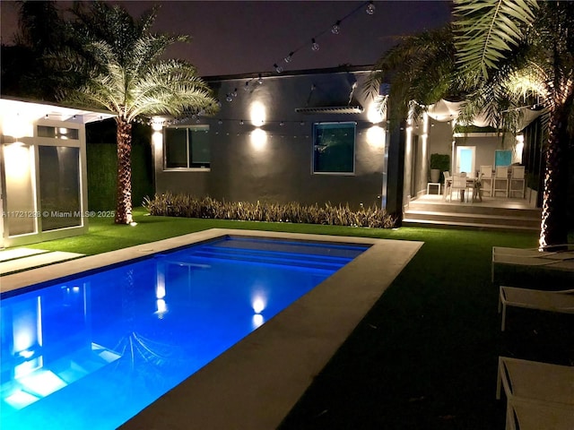 pool at twilight with a patio