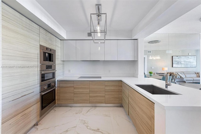 kitchen featuring kitchen peninsula, white cabinetry, hanging light fixtures, and sink