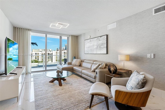 living room with a textured ceiling and floor to ceiling windows