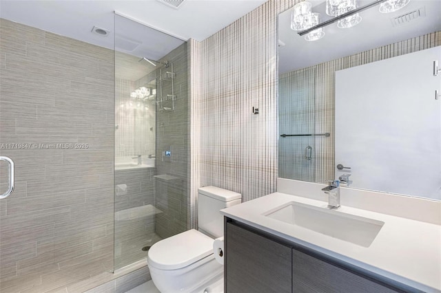 bathroom with vanity, a shower with shower door, and toilet