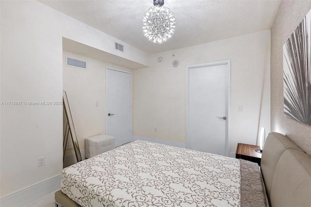 bedroom with a textured ceiling and an inviting chandelier