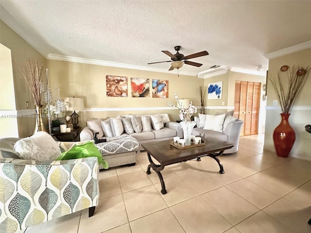 tiled living room with a textured ceiling, ceiling fan, and ornamental molding