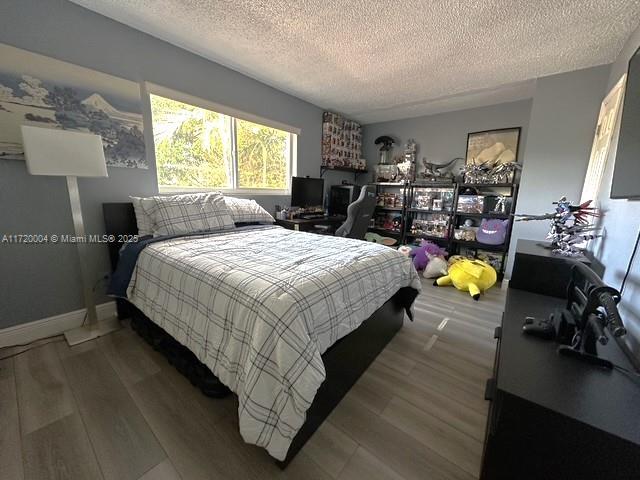 bedroom with hardwood / wood-style floors and a textured ceiling