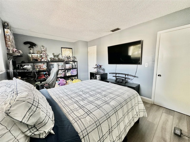 bedroom featuring wood-type flooring and a textured ceiling