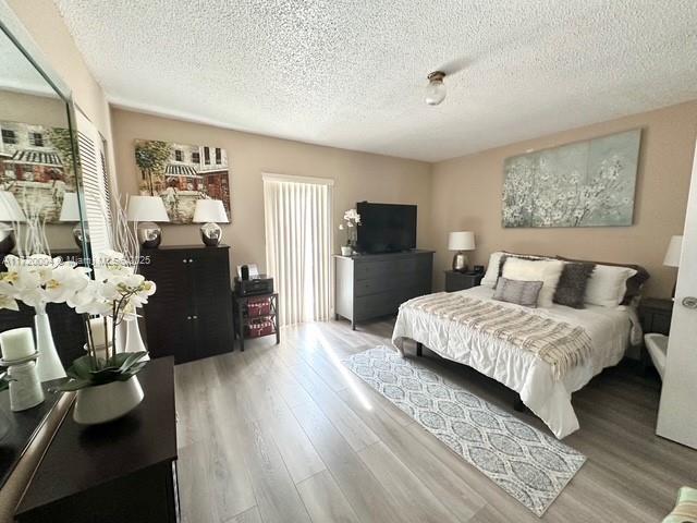 bedroom featuring hardwood / wood-style floors and a textured ceiling