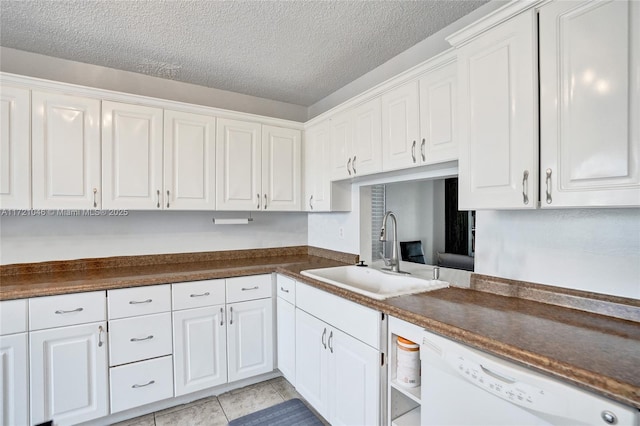 kitchen featuring white cabinetry, sink, white dishwasher, a textured ceiling, and light tile patterned floors