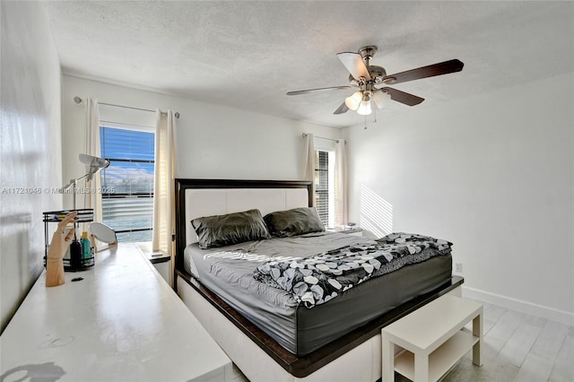 bedroom featuring ceiling fan, hardwood / wood-style floors, and a textured ceiling