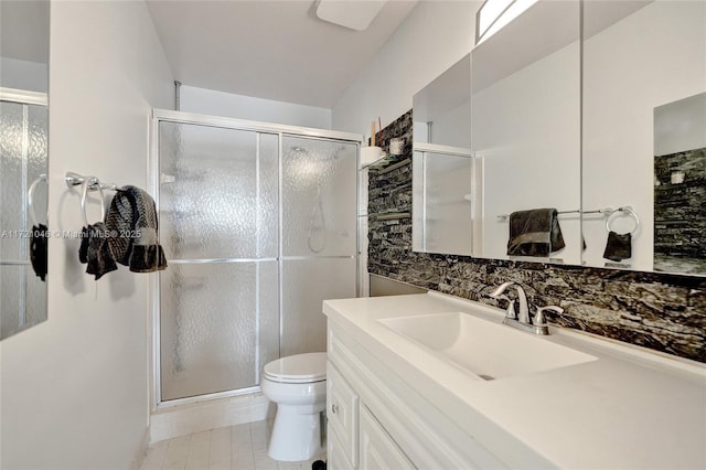 bathroom featuring tile patterned floors, vanity, toilet, and walk in shower