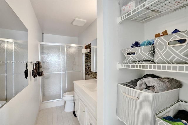 bathroom featuring vanity, an enclosed shower, and toilet