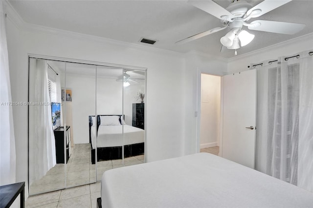 tiled bedroom featuring ceiling fan, ornamental molding, and a closet