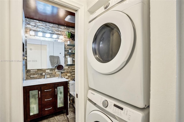 washroom featuring sink and stacked washing maching and dryer