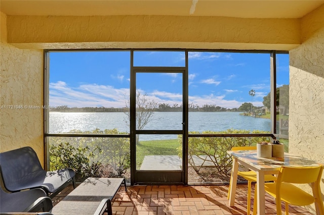 sunroom / solarium featuring a water view