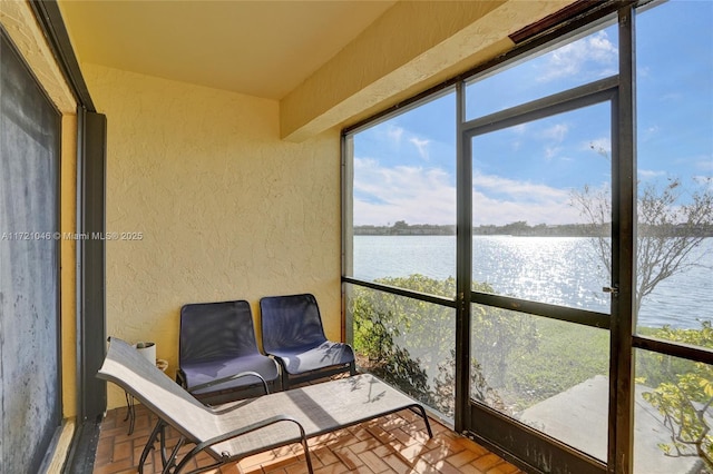 sunroom / solarium featuring a water view