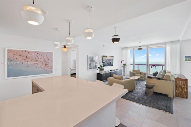 kitchen featuring a center island, light tile patterned floors, pendant lighting, and a wall of windows