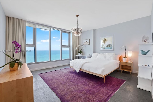 bedroom with a water view and an inviting chandelier