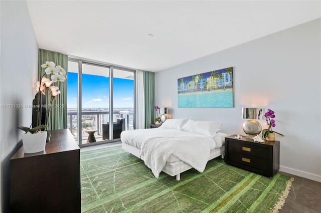 bedroom with expansive windows and access to exterior