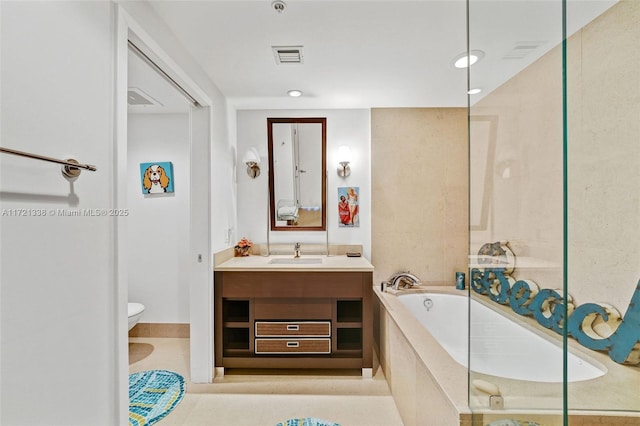 bathroom with tile patterned floors, vanity, a relaxing tiled tub, and toilet