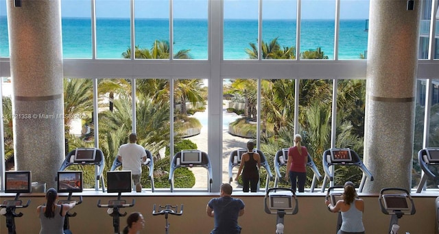 gym featuring a water view and a healthy amount of sunlight