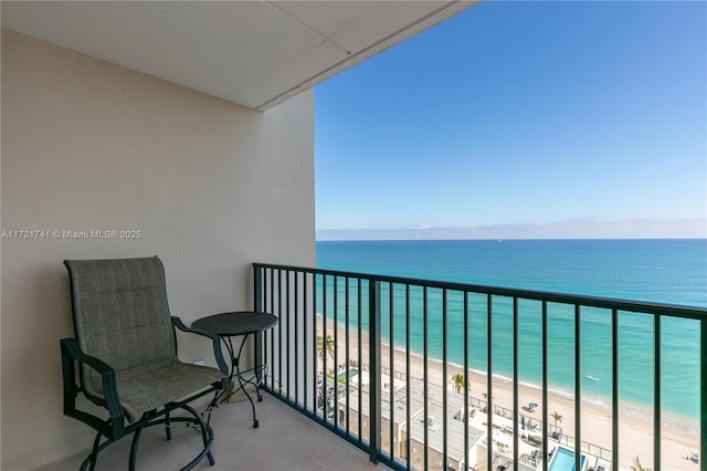 balcony featuring a beach view and a water view