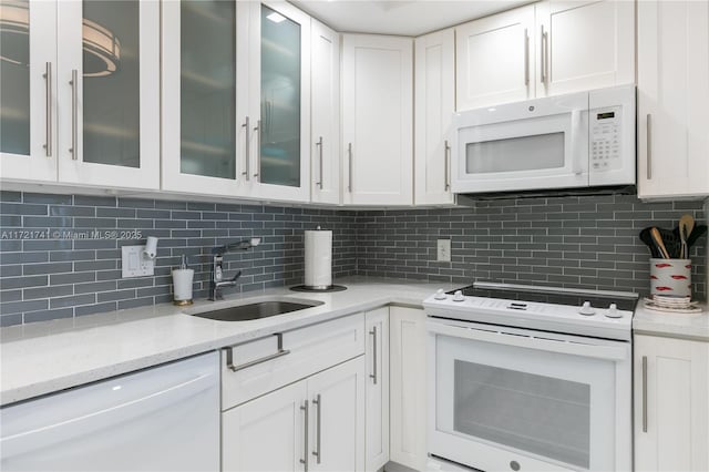 kitchen with white cabinets, white appliances, tasteful backsplash, and sink