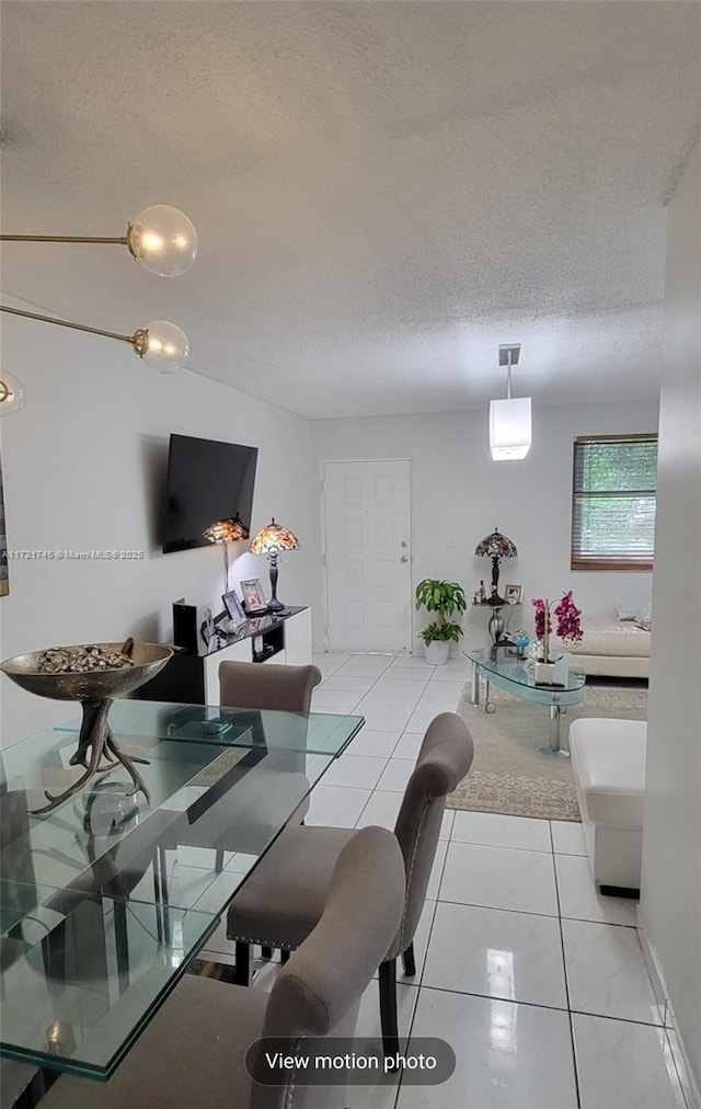 tiled dining space with a textured ceiling