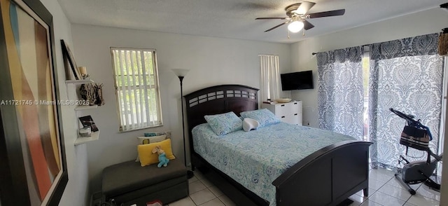 tiled bedroom featuring ceiling fan and a textured ceiling