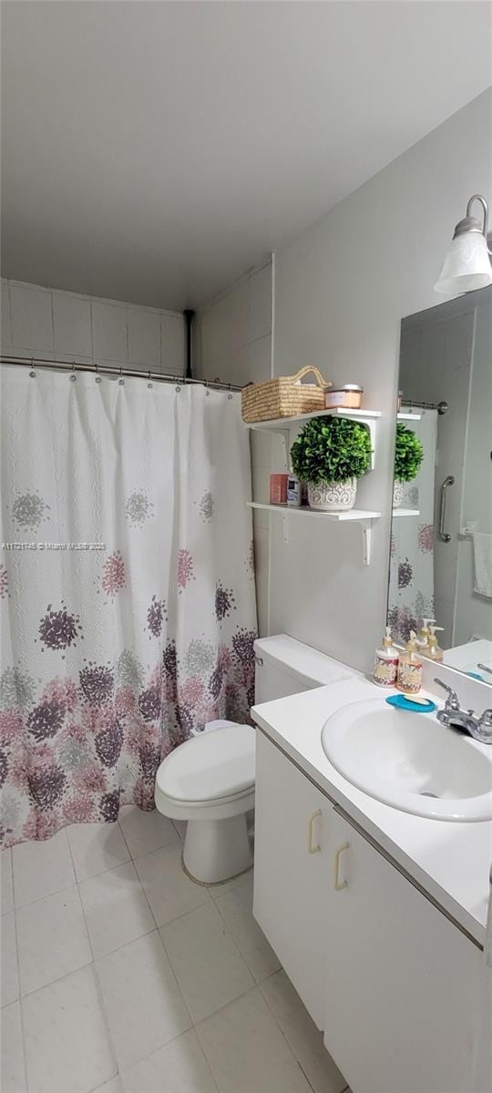 bathroom with tile patterned flooring, vanity, and toilet