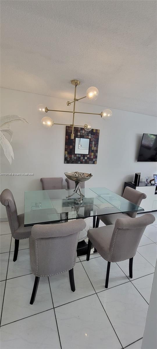 tiled dining room with a textured ceiling