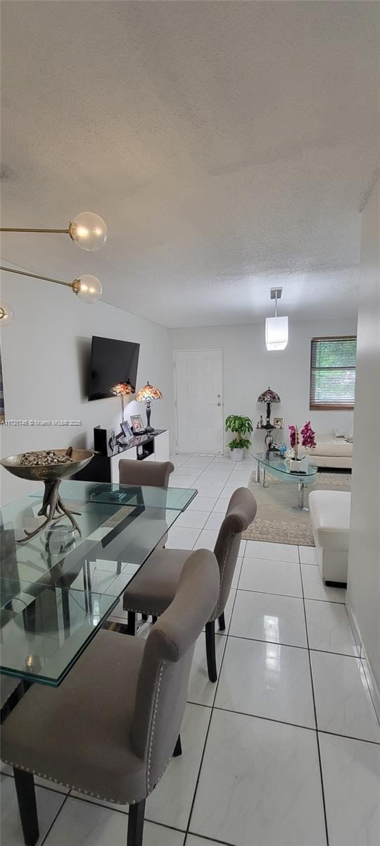 dining room with light tile patterned flooring and a textured ceiling