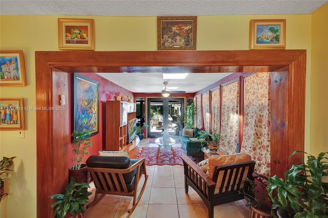 hall featuring french doors, light tile patterned floors, and a textured ceiling