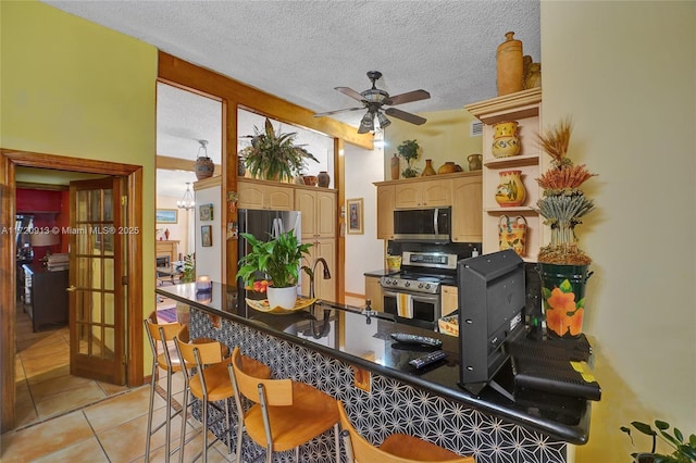 interior space with light tile patterned floors, a textured ceiling, ceiling fan, and sink