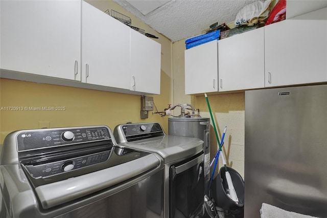 washroom with washer and clothes dryer, cabinets, and a textured ceiling