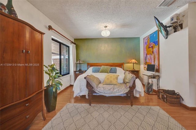 bedroom featuring a textured ceiling and light wood-type flooring