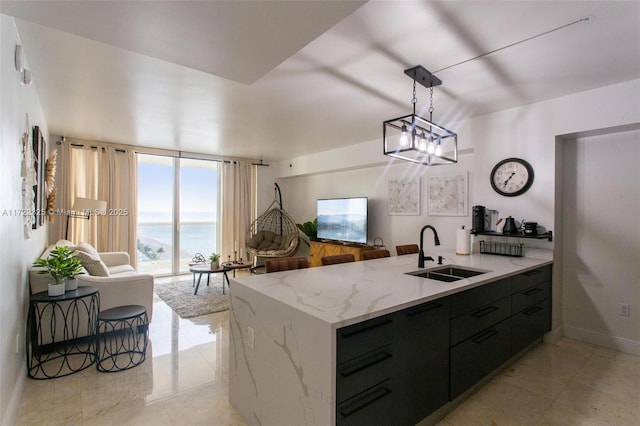 kitchen with light stone countertops, decorative light fixtures, floor to ceiling windows, and sink